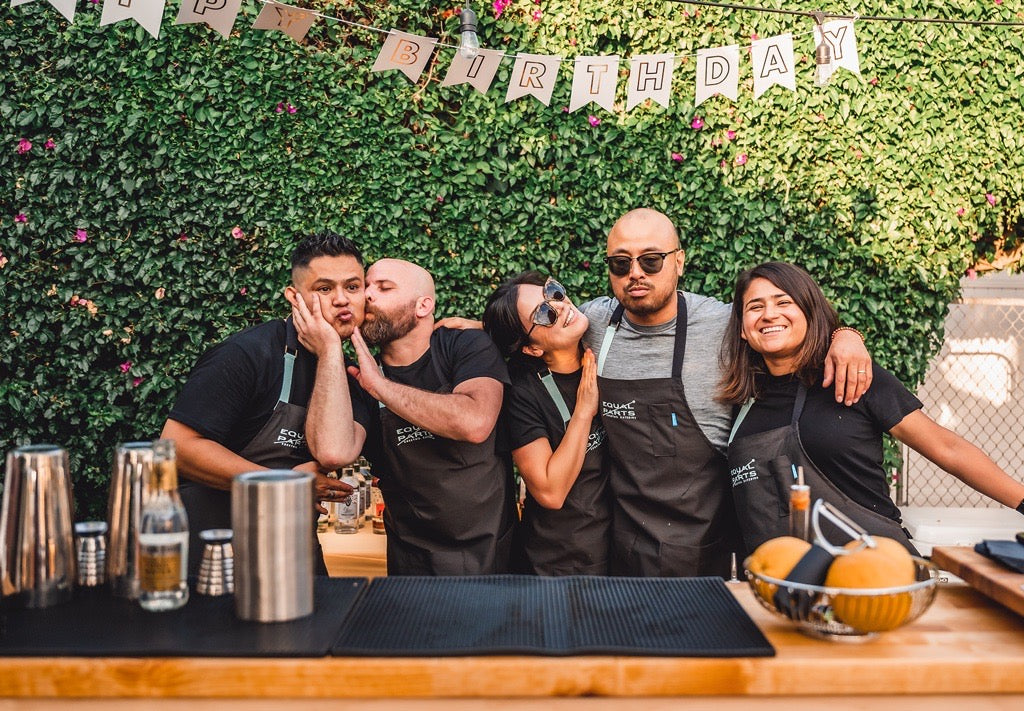 Group wearing customized aprons at an outdoor bar