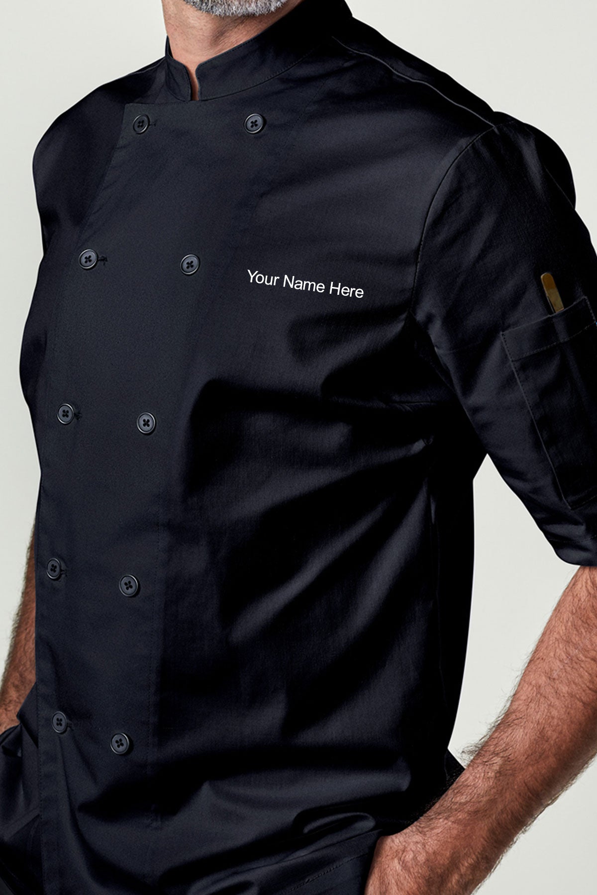 Man wearing a personalized black double-breasted short sleeve chef coat.