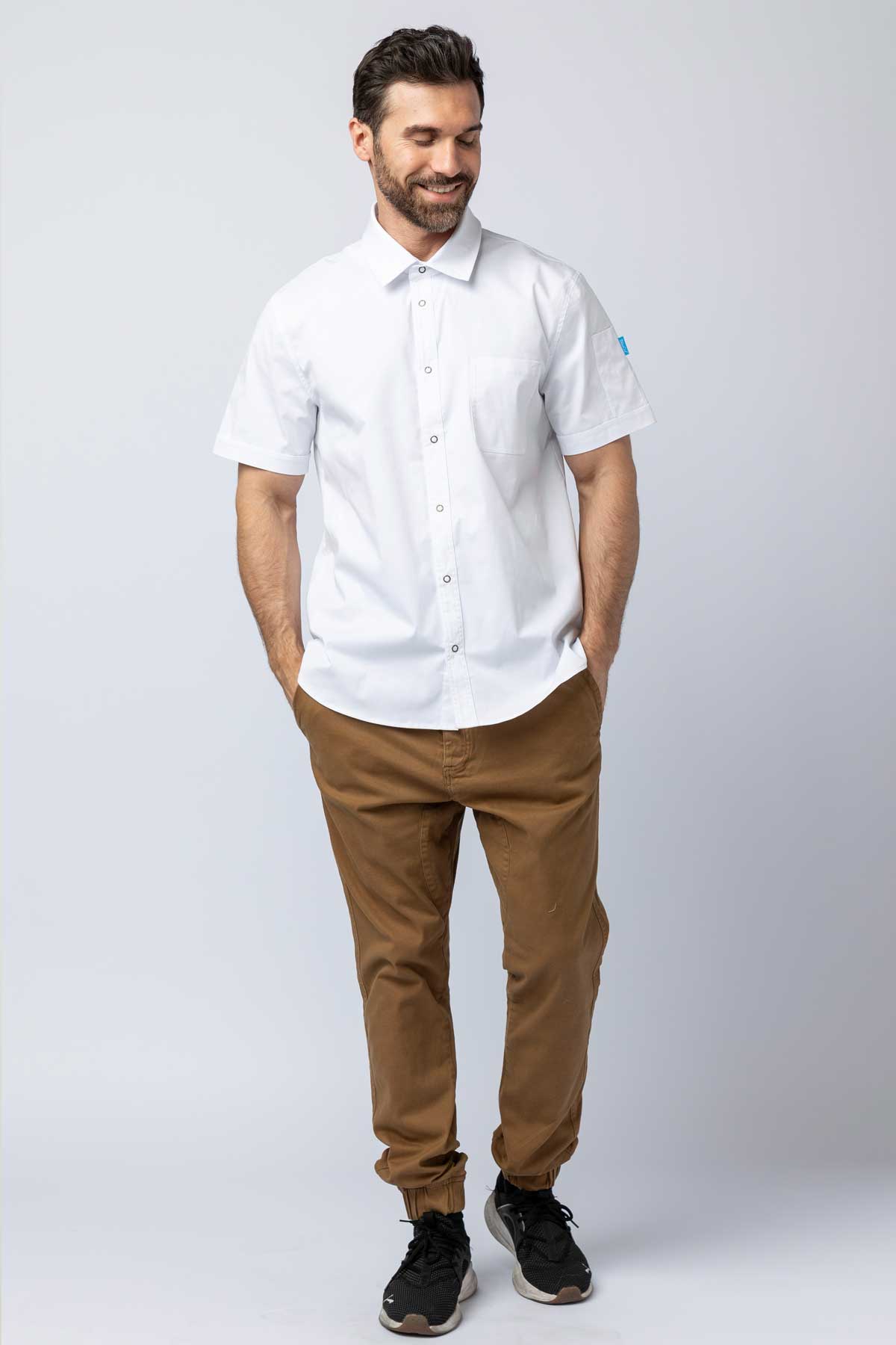 Man wearing khaki joggers and a white work shirt.