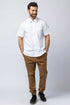 Man wearing khaki joggers and a white work shirt.