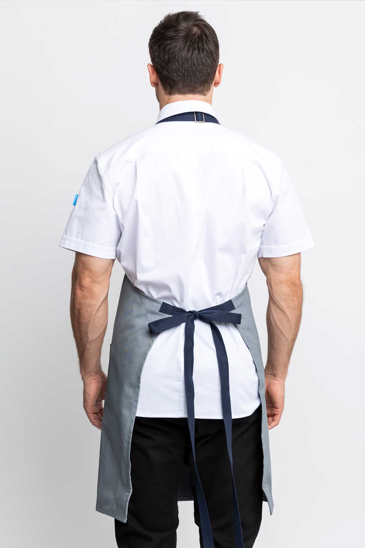 Back view of a man wearing an silver grey-colored denim apron