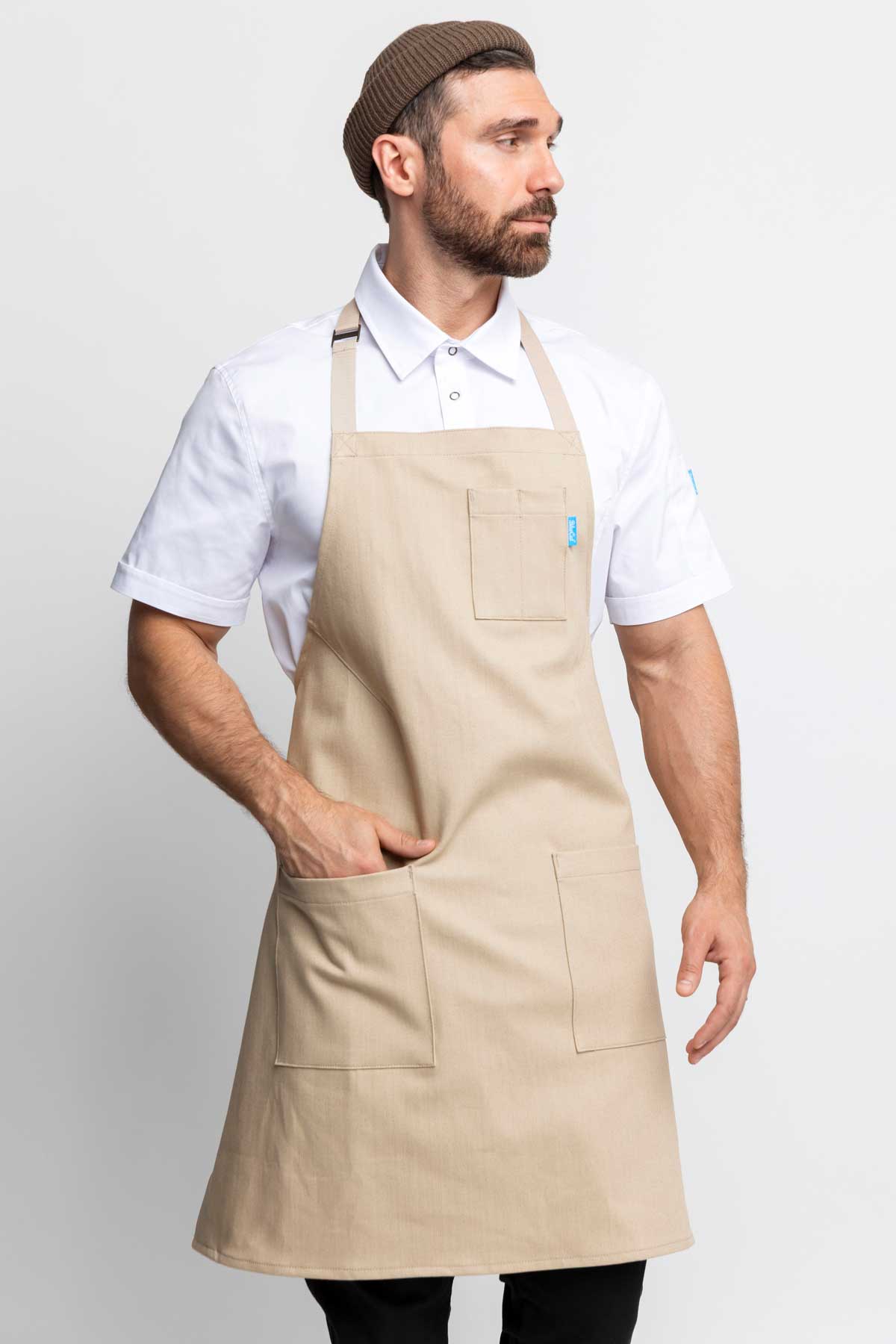 Three-quarter view of a man wearing an oatmeal denim apron
