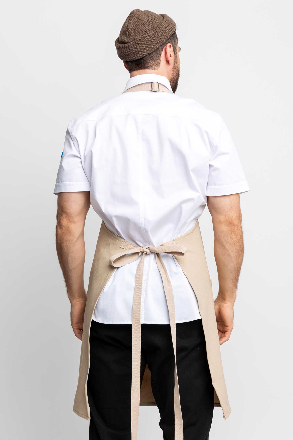 Back view of a man wearing an oatmeal denim apron