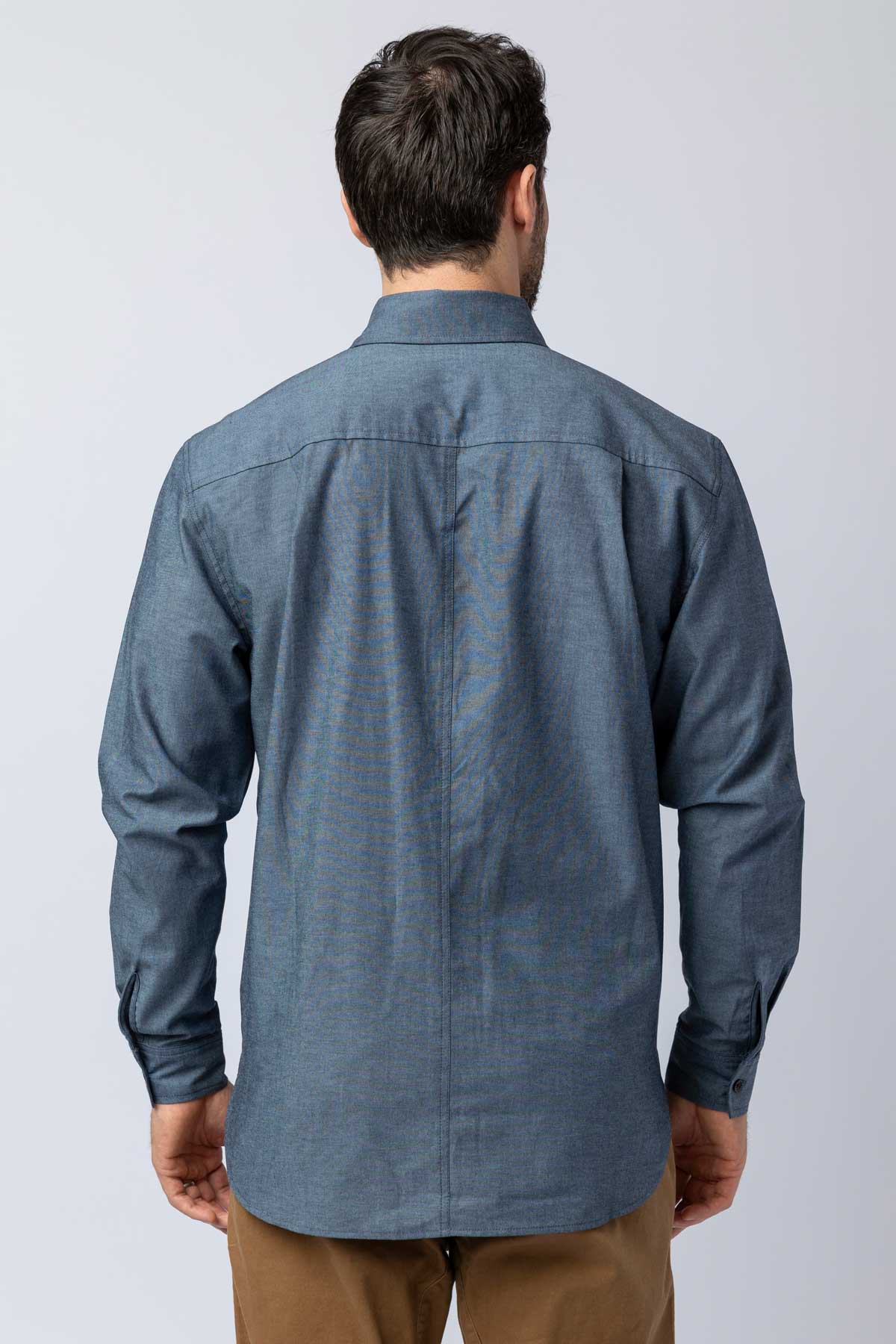 Rear view of men wearing blue long-sleeve chambray button-down shirts.