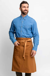 Man wearing a blue shirt and brown bistro apron on a white background