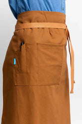Brown bistro apron worn by a person on a white background