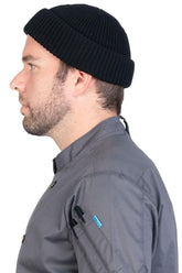 Profile close-up of a man wearing a black beanie.