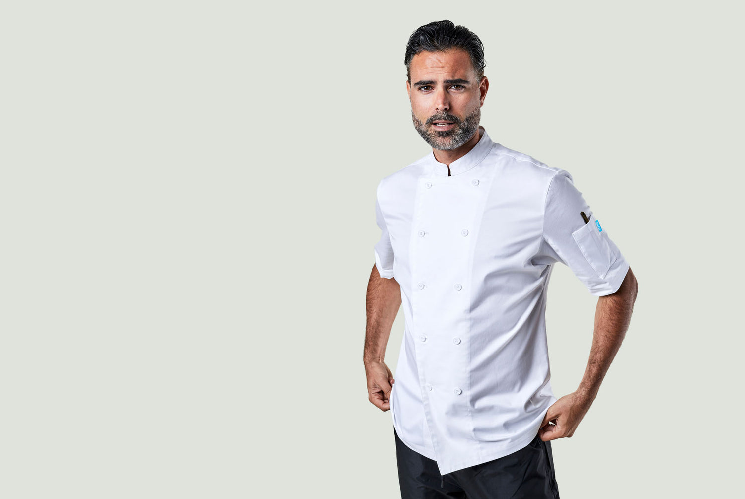 A man wearing a white double breasted chef coat. 