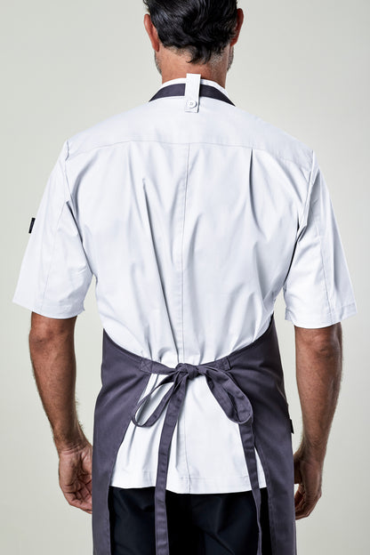 Back view of a man wearing a white shirt and gray apron on a plain background