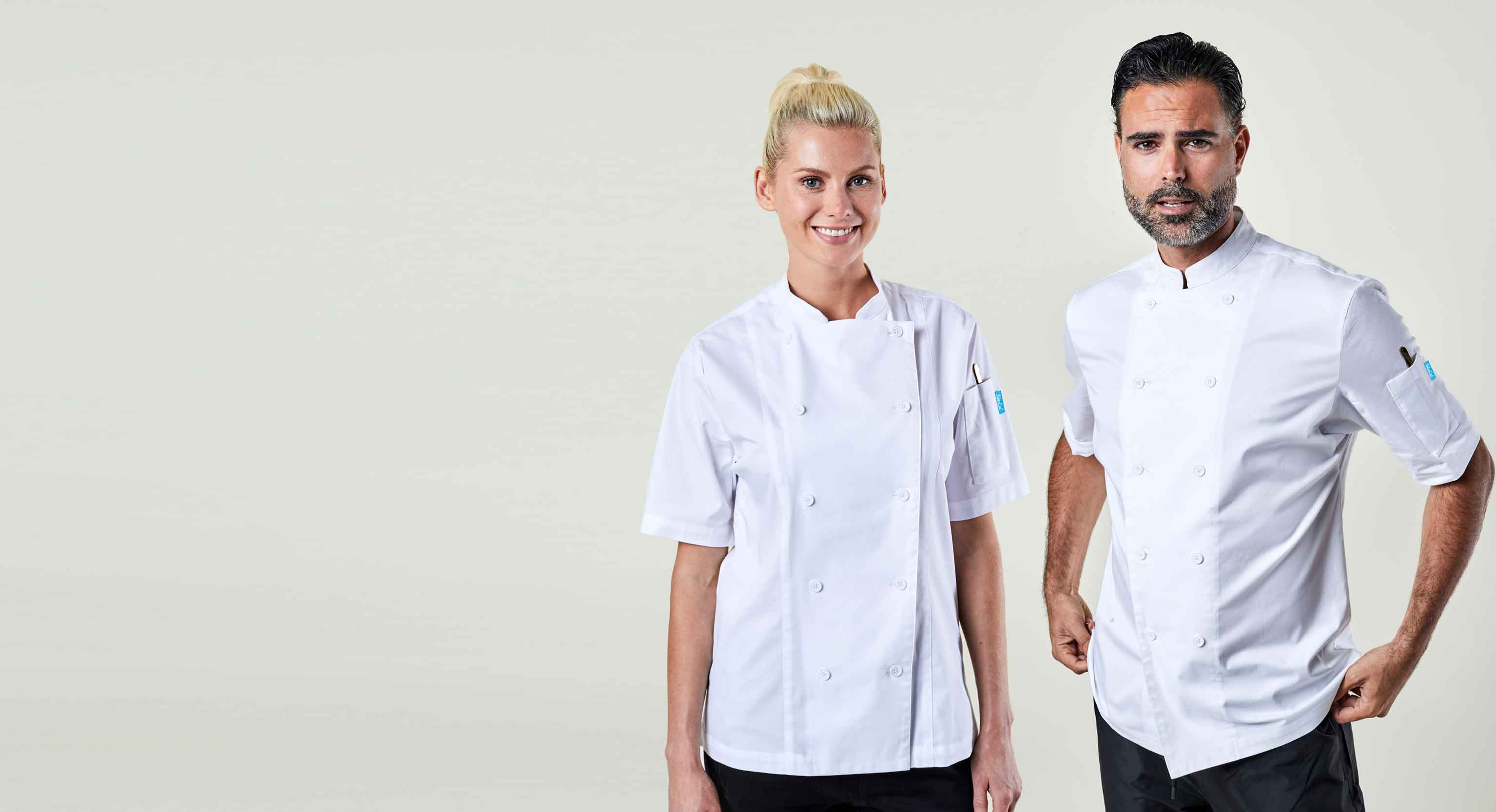 Two chefs wearing white chef coats on a plain background