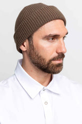 Profile close-up of a man wearing a brown beanie.