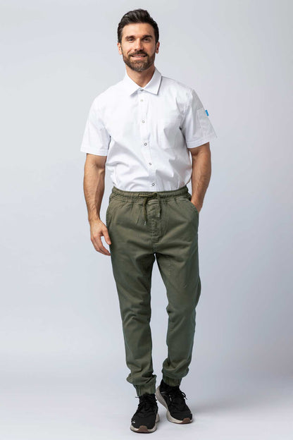 Man wearing olive joggers and a white work shirt.