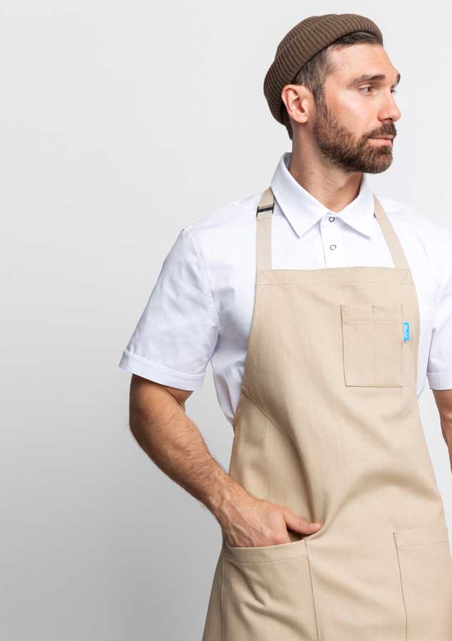 Man wearing a beige apron and white shirt on a light gray background