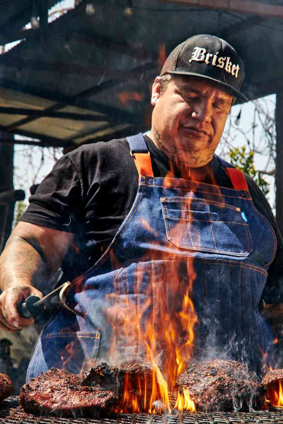 Image of a person grilling wearing Pitmaster apron. | BlueCut Aprons