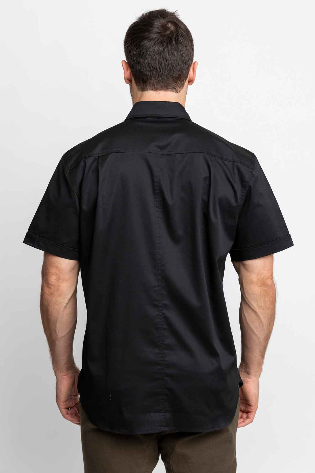 Back view of men wearing black short-sleeve button-down shirts.
