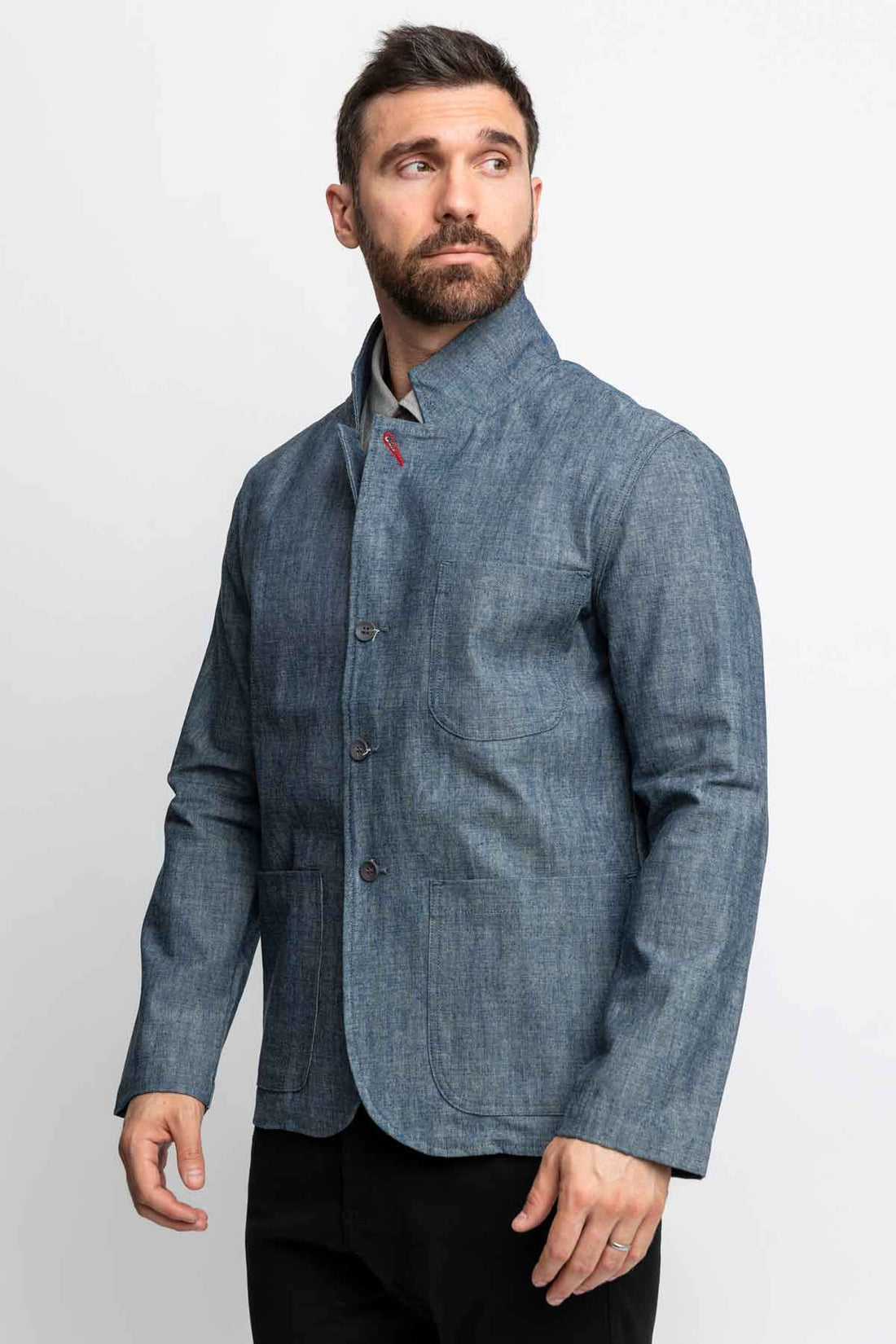 Three-quarter view of a man wearing a blue chambray task jacket.