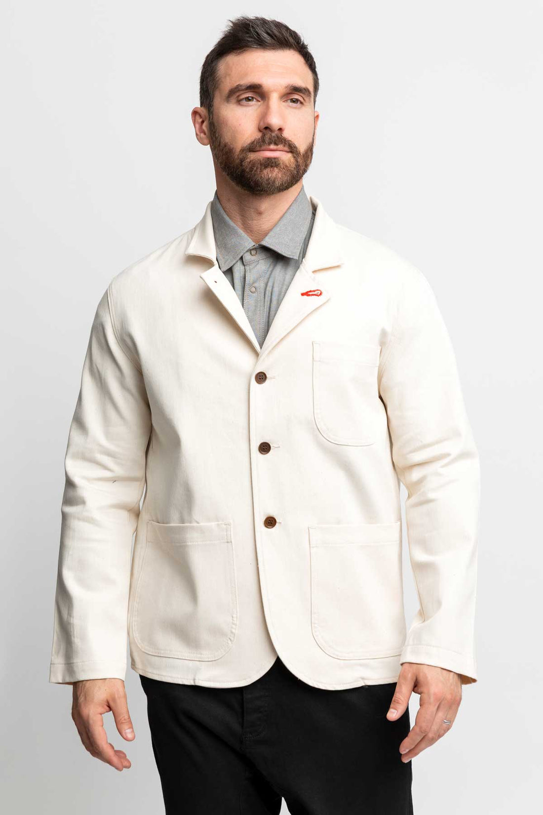 Front view of a man wearing a task jacket in natural color.