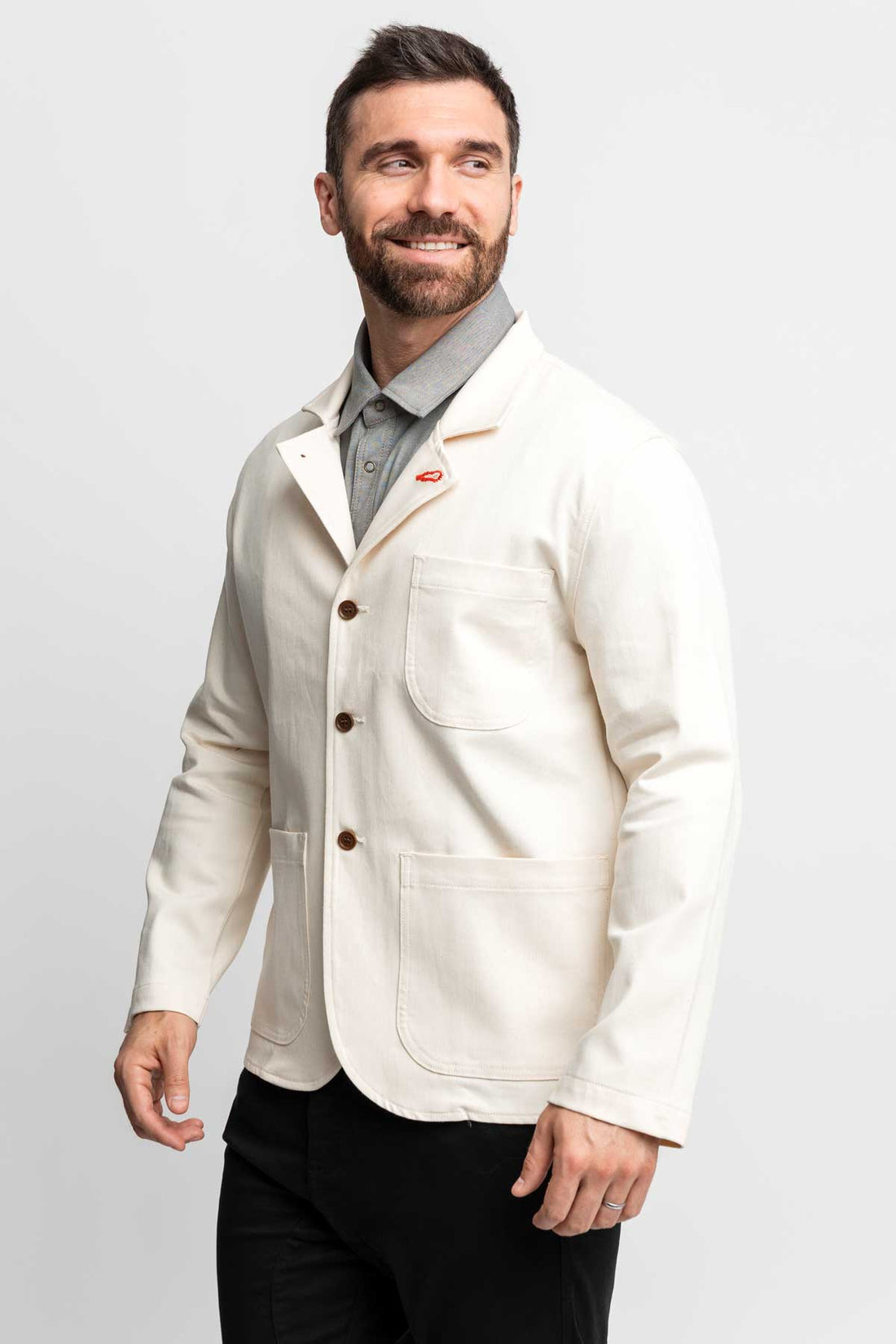 Three-quarter view of a man wearing a natural-colored task jacket.
