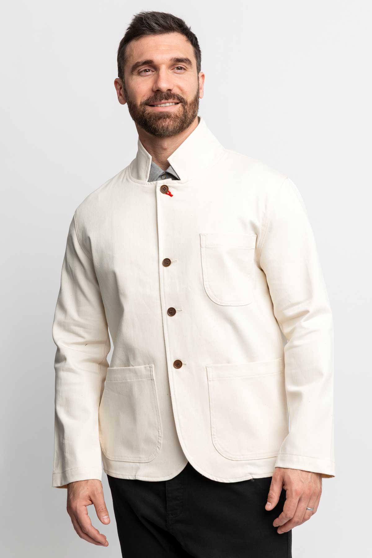Front view of a man wearing a fully buttoned natural-colored task jacket.