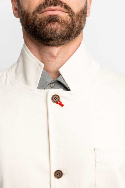 Detail view of a man wearing a task jacket in natural color.