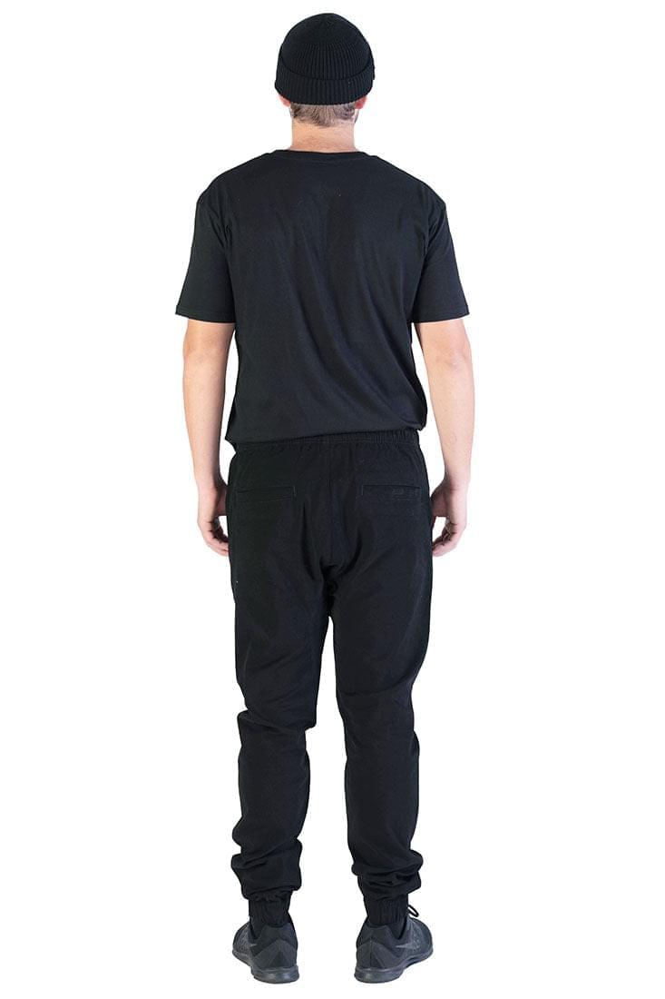 Rear view of man wearing black joggers and a black t-shirt. 
