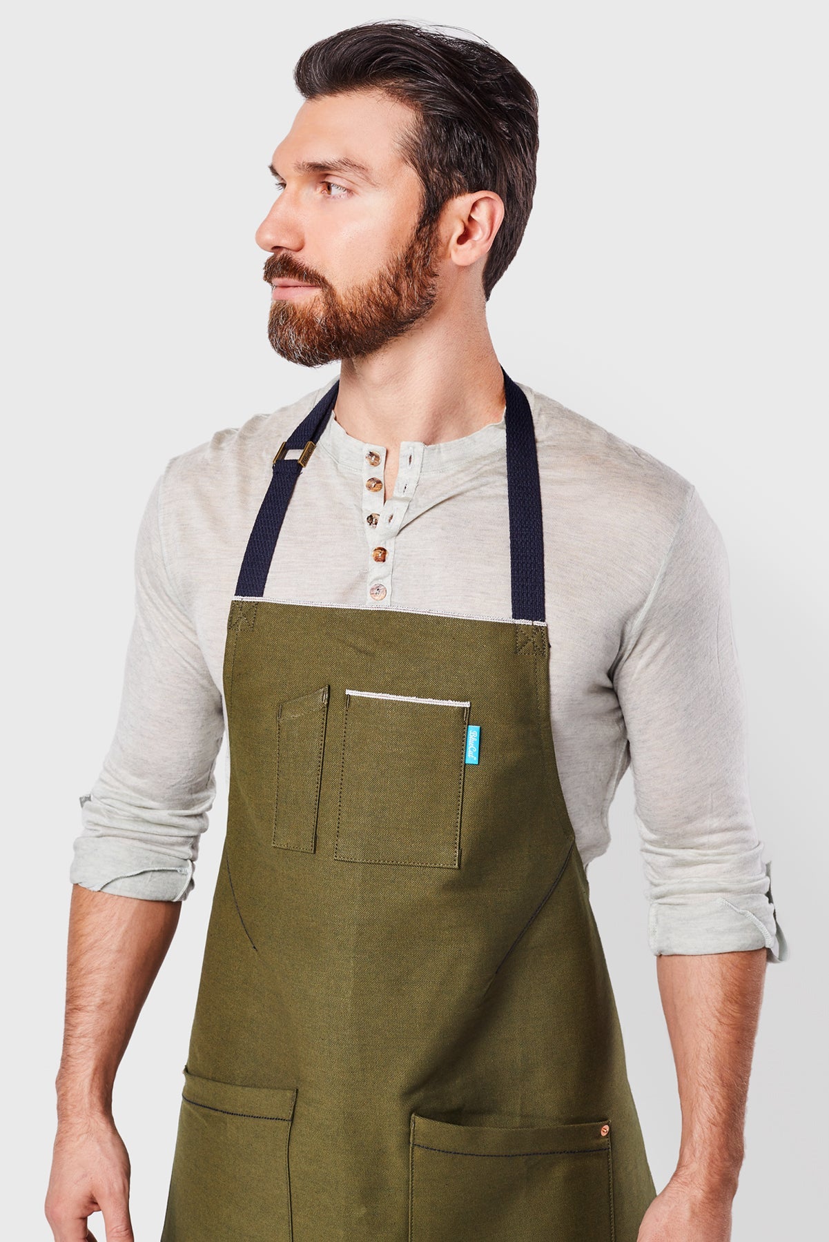 Close up image of person wearing Mason Apron in Olive Selvage Denim. | BlueCut Aprons